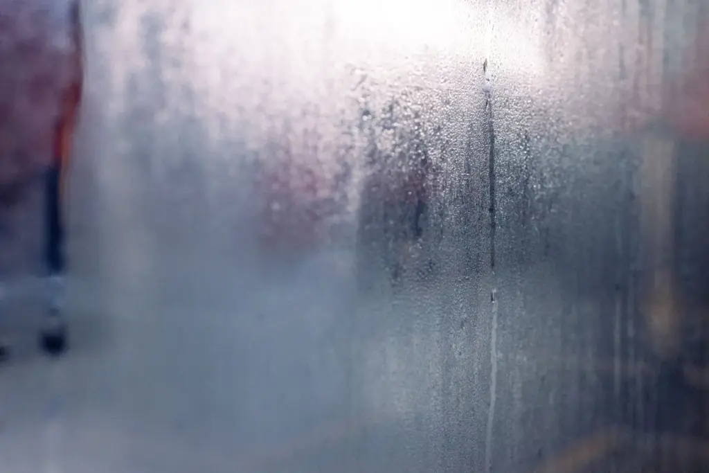 Kondenswasser und Wassertropfen auf einer von innen beschlagenen Fensterscheibe