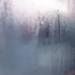Kondenswasser und Wassertropfen auf einer von innen beschlagenen Fensterscheibe
