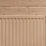Weißer Plattenheizkörper mit Entlüftungsventil links und Thermostatventil rechts