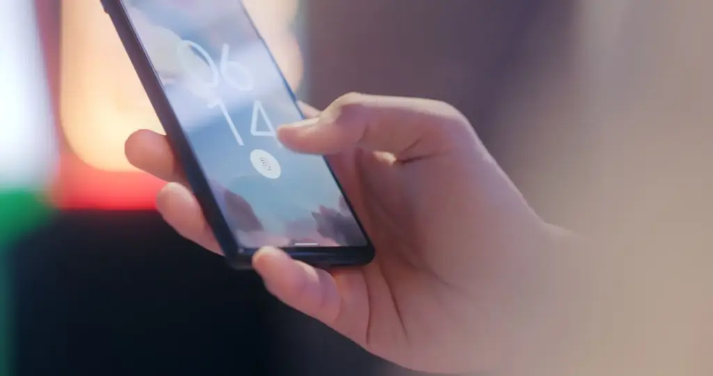 Hand entsperrt ein Smartphone über den Fingerabdrucksensor