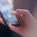 Hand entsperrt ein Smartphone über den Fingerabdrucksensor