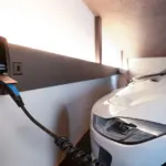 Elektroauto lädt an einer Wallbox mit digitaler Leistungsanzeige von 3,49 Kilowatt