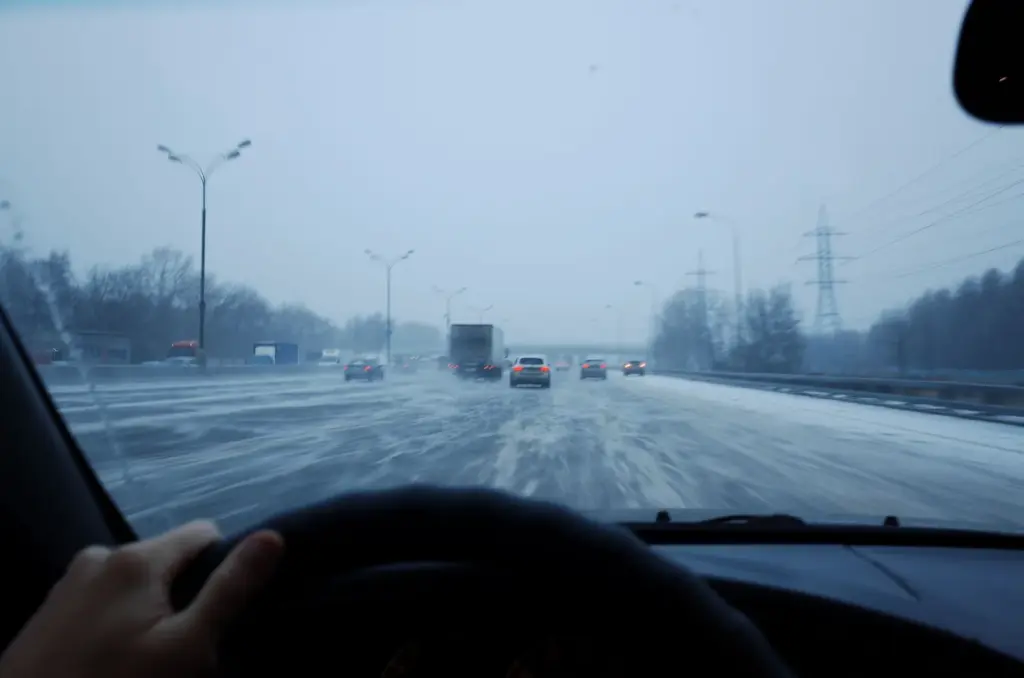 Blick aus einem Auto auf eine stark winterglatte Straße mit Verkehr