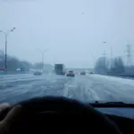 Blick aus einem Auto auf eine stark winterglatte Straße mit Verkehr