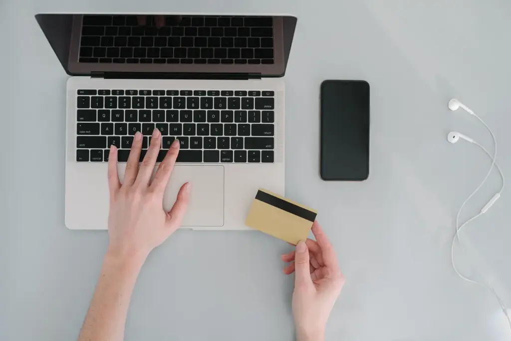 Person gibt am Laptop Daten für eine Online-Zahlung ein