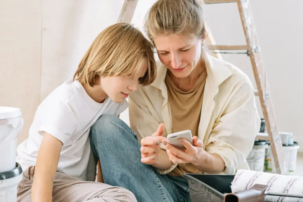 Mutter und Sohn richten gemeinsam ein Smartphone ein