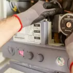 Fachkraft führt Wartungsarbeiten an einer geöffneten Heiztherme durch