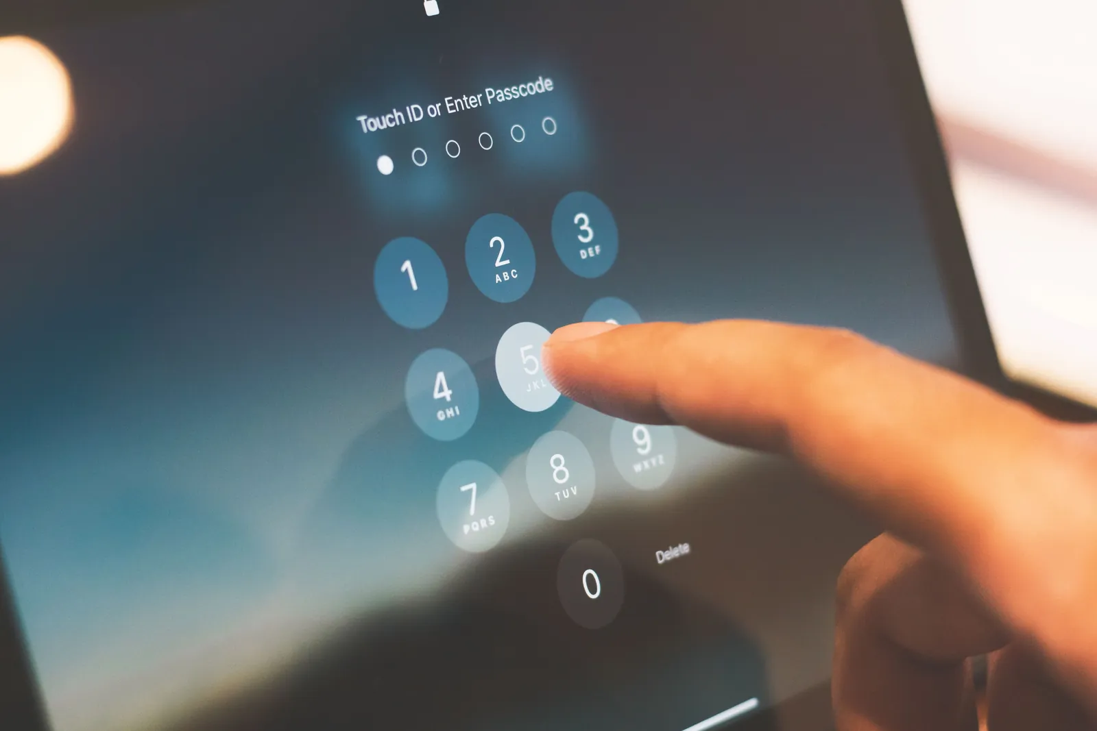 Finger gibt einen Gerätecode auf dem Sperrbildschirm ein