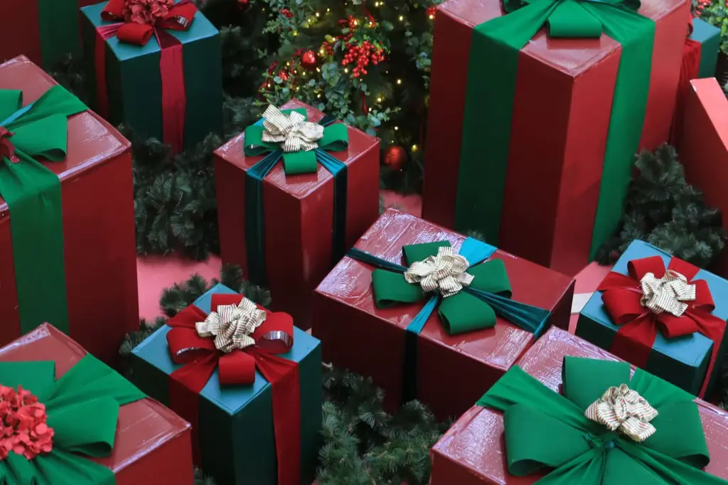 Rot und grün verpackte Weihnachtsgeschenke vor festlicher Dekoration